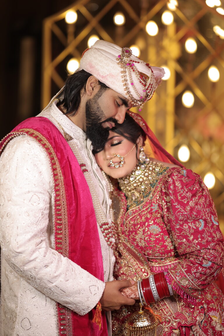 Wedding photography of a bride and groom sharing a romantic moment during their wedding ceremony with elegant floral décor and warm lighting.